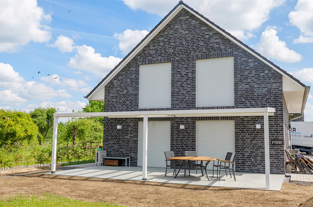 Senden: Fertige Terrasse mit quadratischen Keramikplatten in Drainbeton